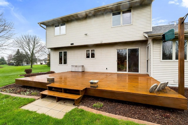 rear view of house featuring a wooden deck and a yard