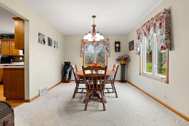 dining space featuring visible vents, baseboards, and an inviting chandelier