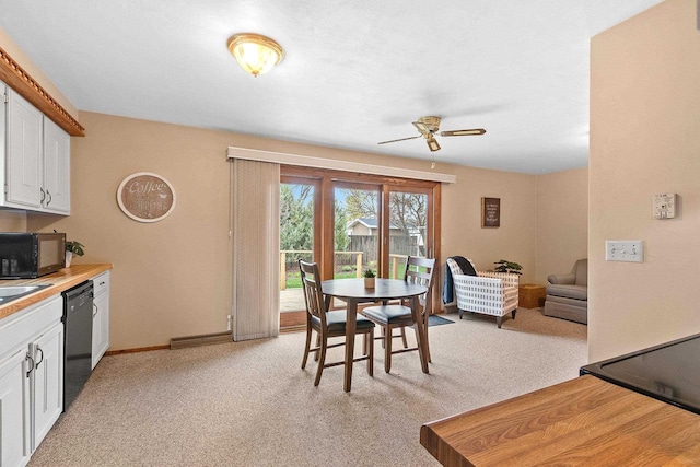 dining space with ceiling fan, light colored carpet, and baseboards