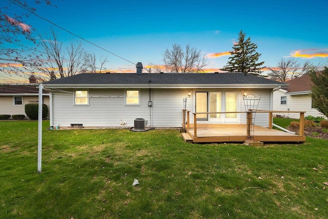 rear view of house with a lawn, roof with shingles, a wooden deck, and central air condition unit