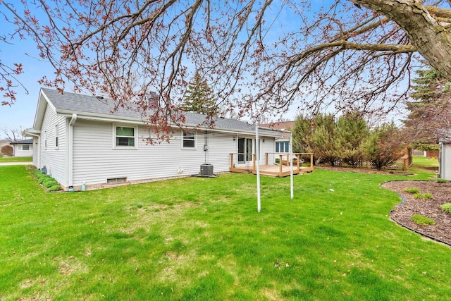 back of house with a lawn, a shingled roof, and a deck