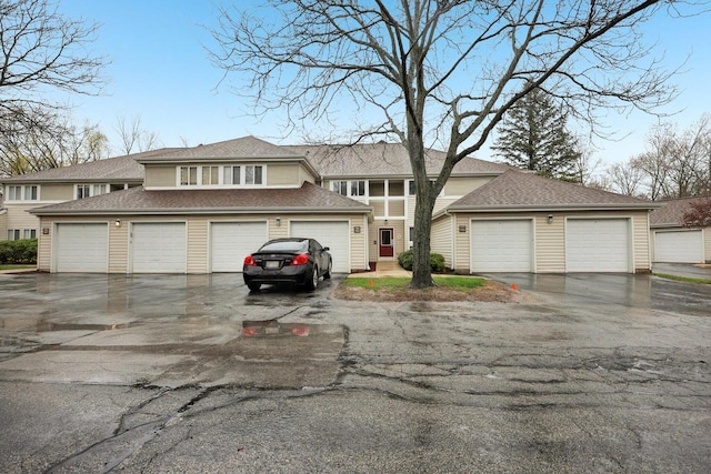 prairie-style house featuring a shingled roof and community garages