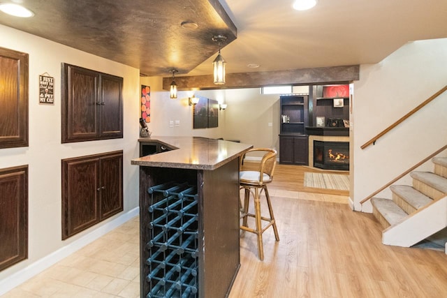 1755 Carmen Ave, Sheboygan, WI 53081 - bar with wet bar, pendant lighting, stairway, baseboards, and a glass covered fireplace