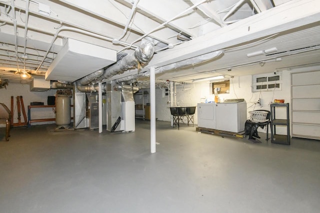 unfinished basement with water heater, heating unit, independent washer and dryer, and a sink