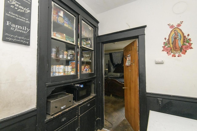 interior space with black microwave and wainscoting