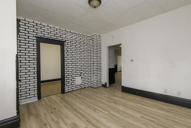 spare room featuring baseboards and wood finished floors