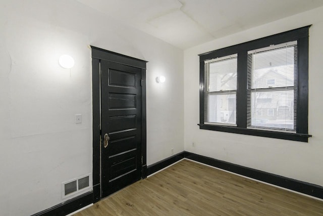 entrance foyer with baseboards, visible vents, and wood finished floors