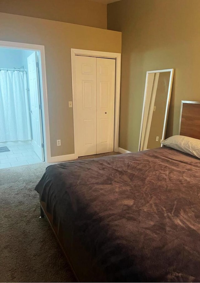 bedroom featuring ensuite bathroom, carpet, and baseboards