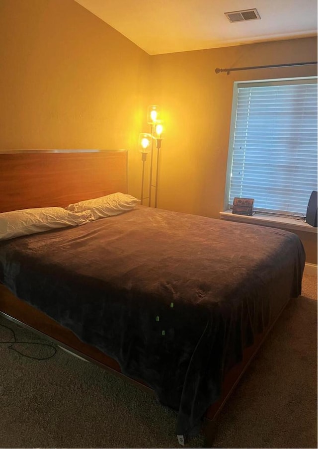 bedroom with visible vents, carpet floors, and vaulted ceiling