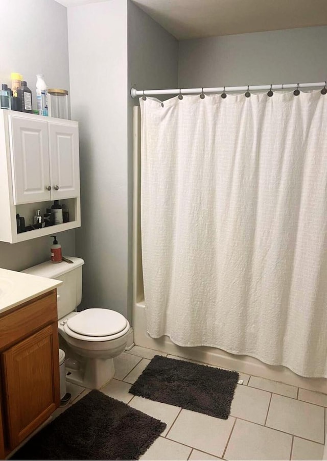 full bath with vanity, toilet, tile patterned flooring, and shower / tub combo