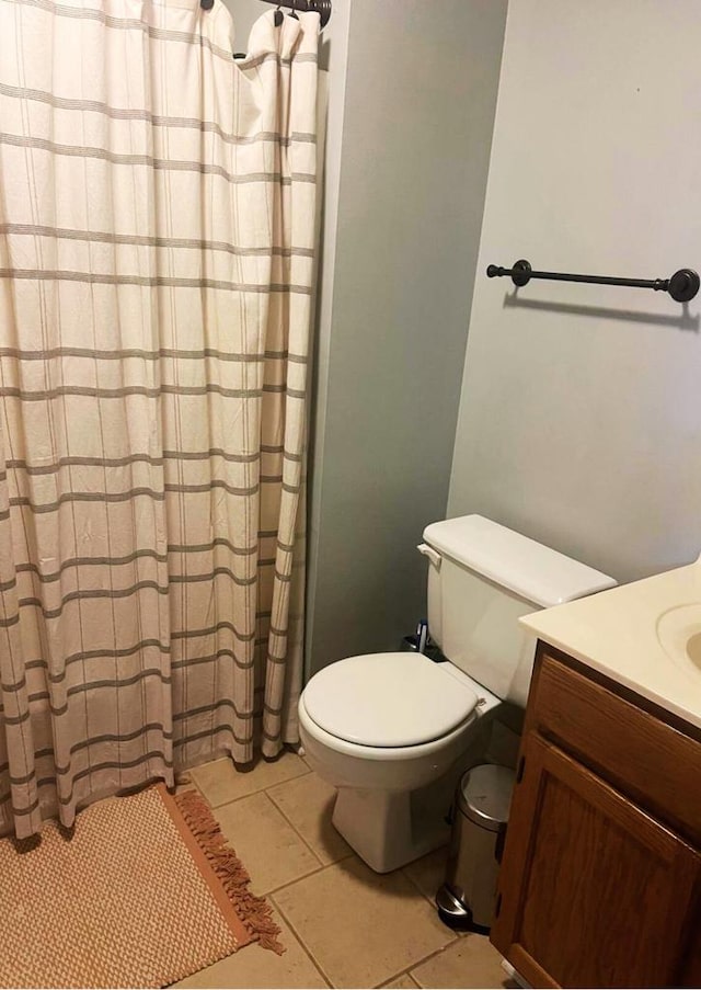 full bath with vanity, tile patterned floors, toilet, and curtained shower