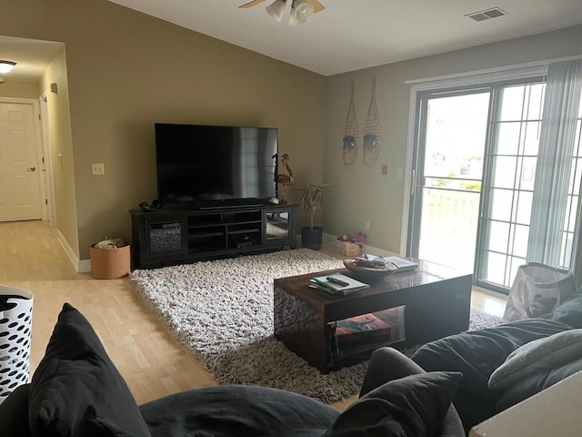 living area featuring baseboards, ceiling fan, wood finished floors, and visible vents