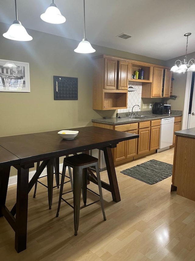 kitchen with visible vents, dark countertops, open shelves, dishwasher, and a sink