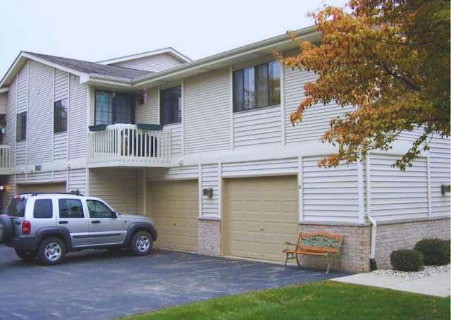 view of property with an attached garage and aphalt driveway