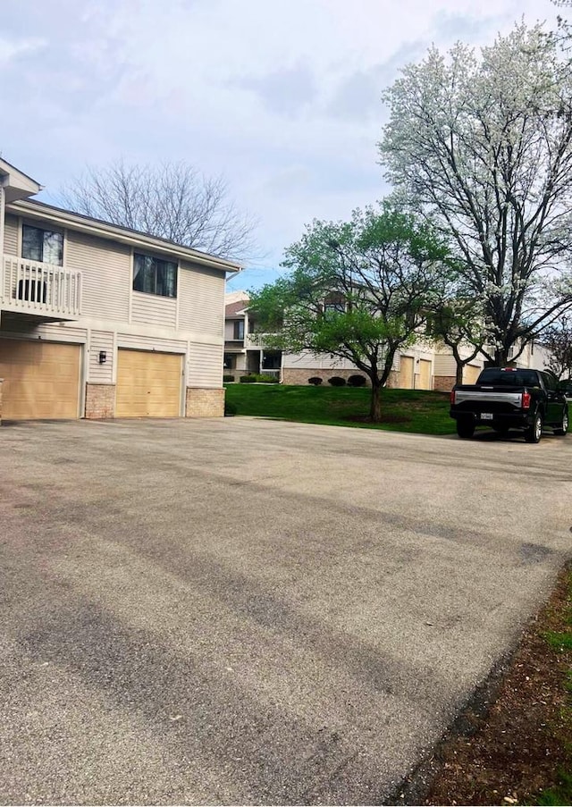view of side of home featuring a garage and aphalt driveway