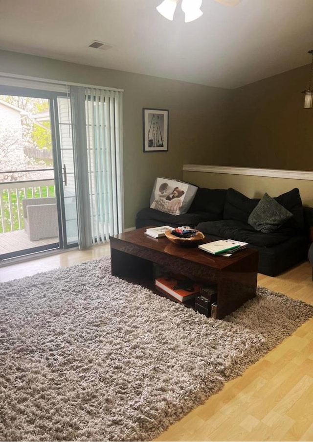 living room with visible vents, ceiling fan, and wood finished floors