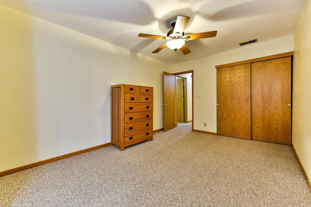 unfurnished bedroom with ceiling fan, visible vents, baseboards, a closet, and light carpet