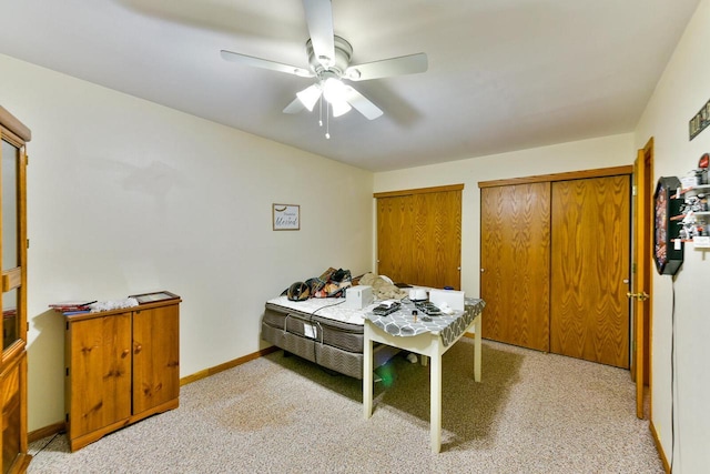 bedroom featuring a ceiling fan, baseboards, and multiple closets