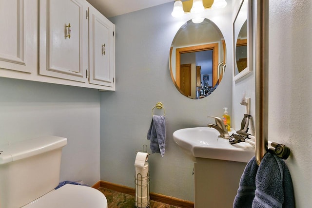 bathroom with vanity, baseboards, and toilet