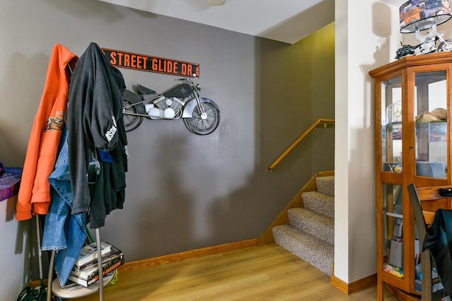interior space with stairway, baseboards, and wood finished floors