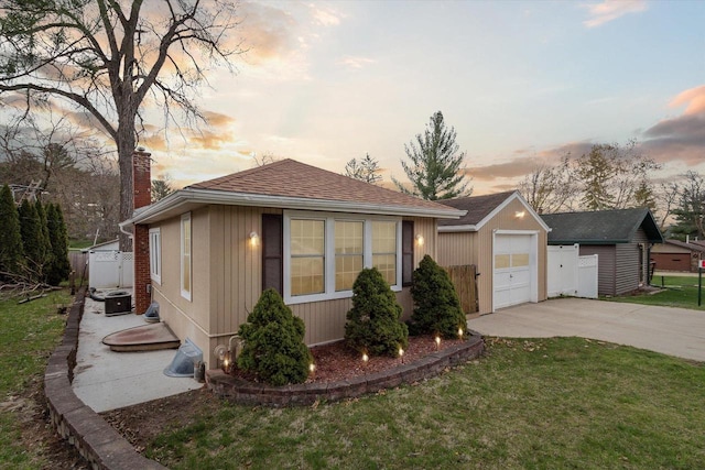 view of front of home featuring driveway, a chimney, central AC unit, fence, and a front lawn