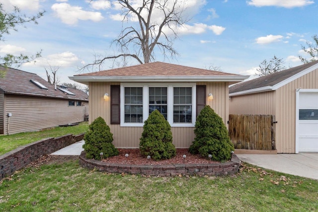 view of front of house with an outbuilding and a front lawn