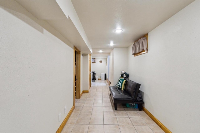 corridor featuring recessed lighting, baseboards, and light tile patterned floors
