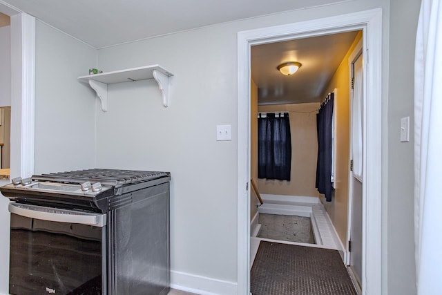 kitchen with open shelves, baseboards, and range with gas cooktop