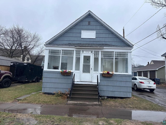 bungalow-style house with entry steps and a shingled roof