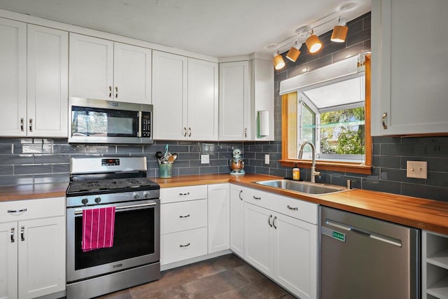 632 N Harrison St, Stoughton, WI 53589 - kitchen with stainless steel appliances, butcher block countertops, a sink, backsplash, and white cabinetry