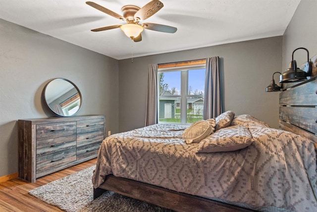 bedroom featuring baseboards, ceiling fan, and wood finished floors