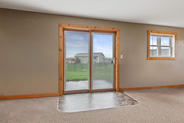 doorway to outside featuring baseboards and carpet