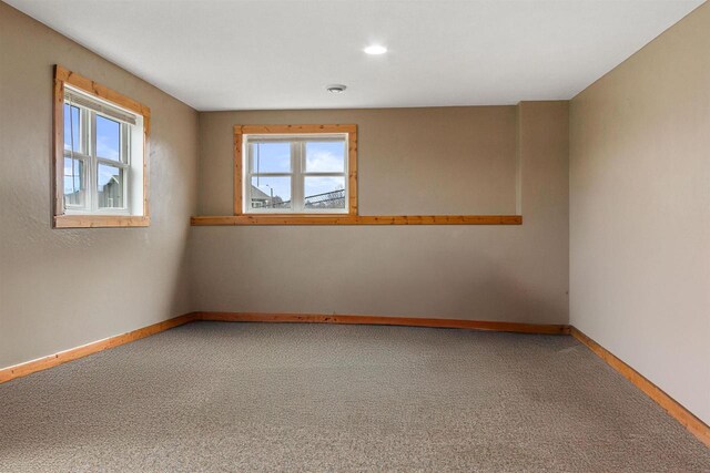 empty room with plenty of natural light, carpet flooring, baseboards, and recessed lighting