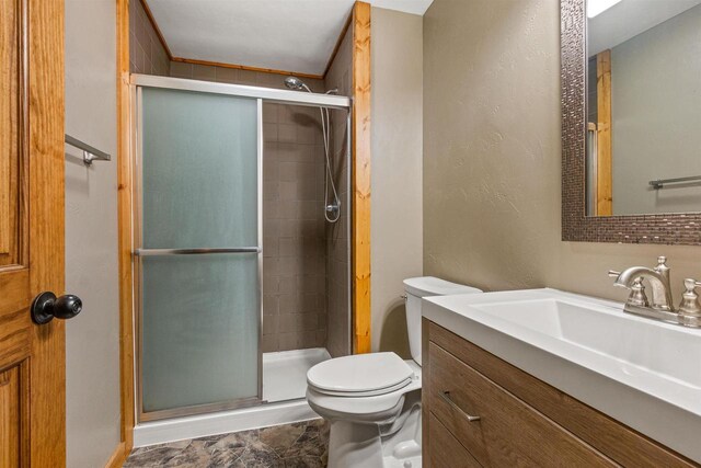 bathroom with vanity, a shower stall, and toilet