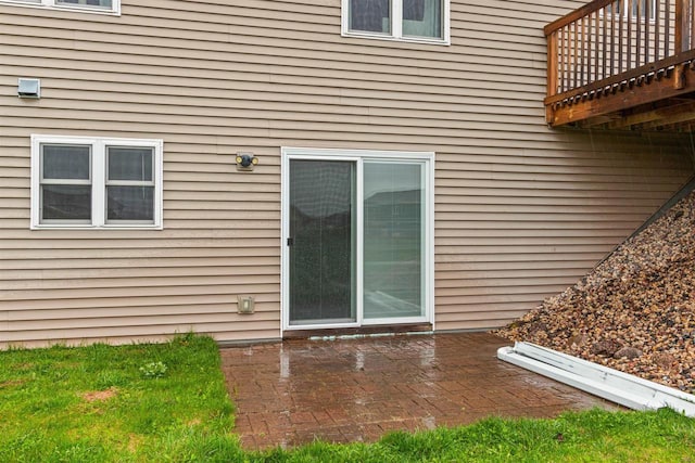 view of exterior entry with a patio