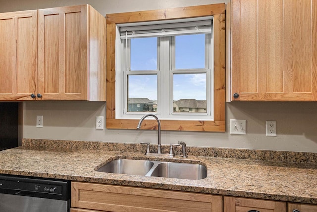 kitchen featuring stainless steel dishwasher, light stone counters, a sink, and light brown cabinets
