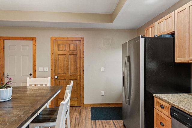 kitchen with stainless steel appliances, light stone countertops, wood finished floors, and light brown cabinets