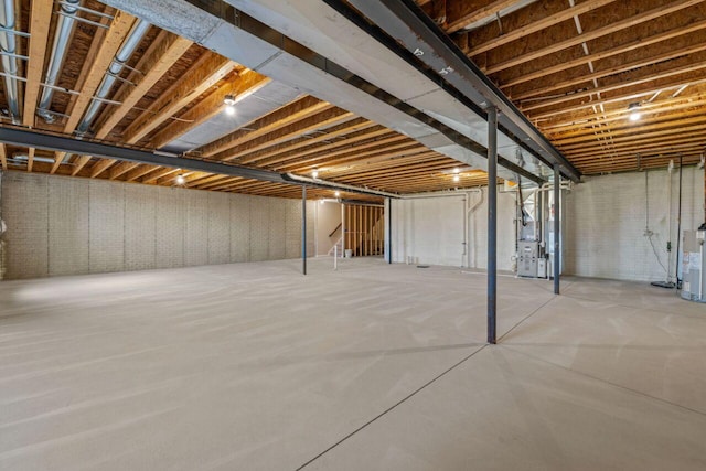 unfinished basement with water heater and heating unit