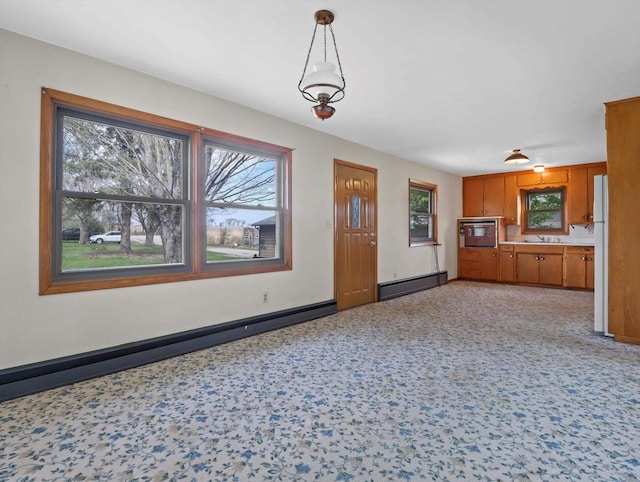 kitchen featuring baseboards, light countertops, a baseboard heating unit, brown cabinets, and a baseboard radiator