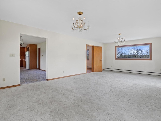 spare room featuring carpet floors, a baseboard radiator, baseboards, and a chandelier