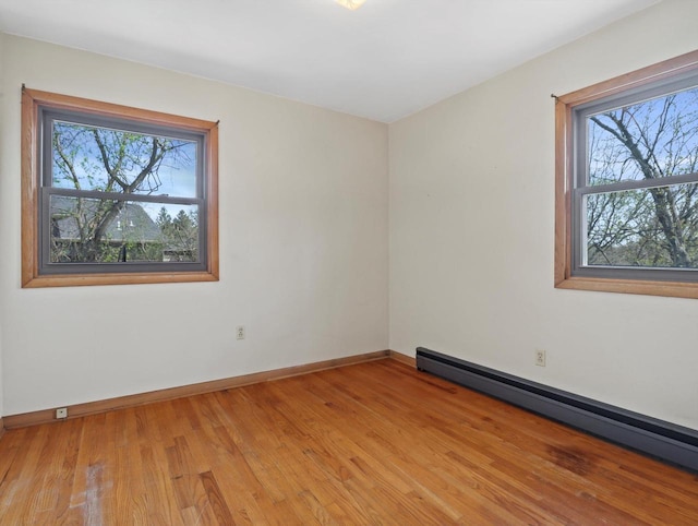 unfurnished room featuring plenty of natural light, baseboards, and baseboard heating