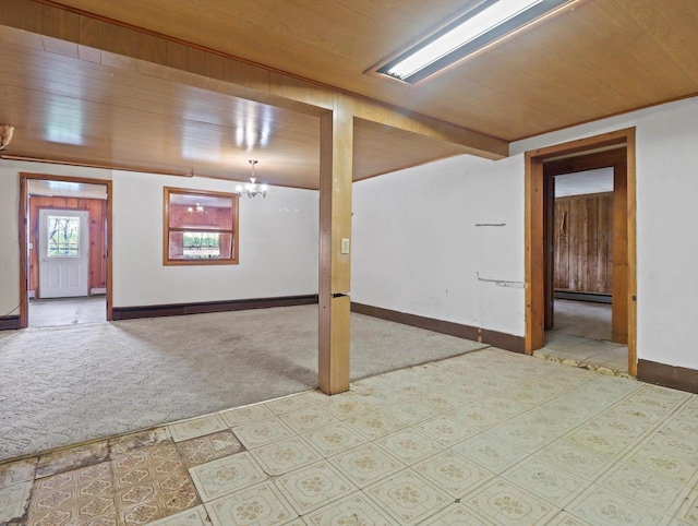 basement featuring wooden ceiling, baseboards, carpet, and a notable chandelier