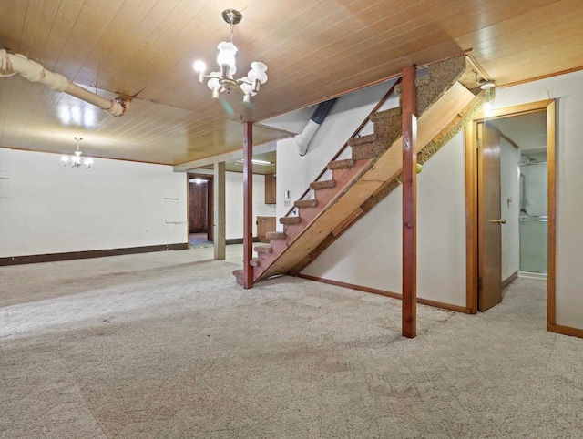 finished below grade area featuring stairs, baseboards, wood ceiling, carpet flooring, and a notable chandelier