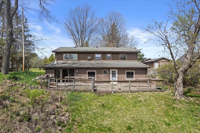 rear view of property with a lawn and a deck