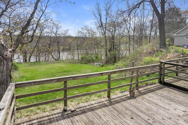wooden terrace with a water view and a yard