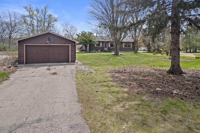 ranch-style house with a detached garage, an outbuilding, and a front yard