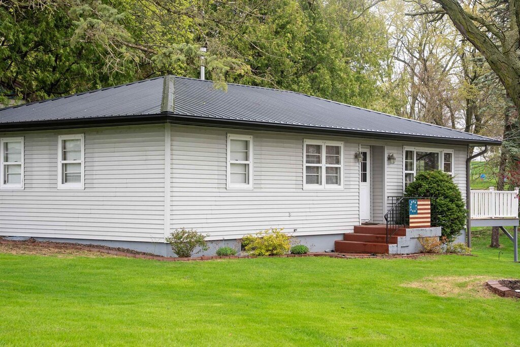 rear view of house with a yard and metal roof