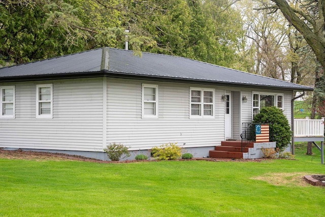 rear view of house with a yard and metal roof