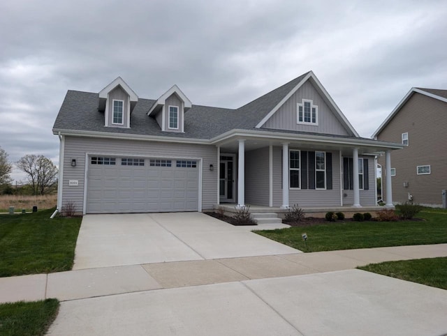 view of front facade featuring concrete driveway, a front lawn, an attached garage, a porch, and board and batten siding