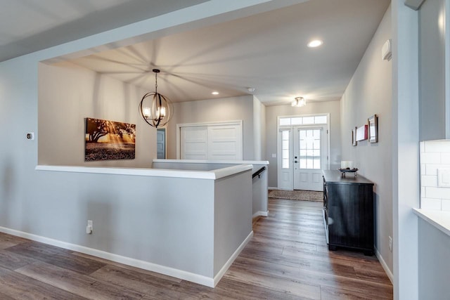 entrance foyer with wood finished floors, recessed lighting, a chandelier, and baseboards